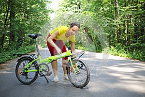 Young woman in sport clothes converts bicycle