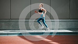 Young woman, sport running and city sidewalk with training, exercise and fitness on urban road. Street, runner profile