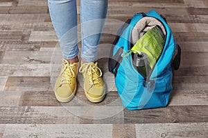 Young woman in sportswear and bag with gym