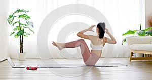 Young woman in  sportswear  doing sports training  on yoga mat at home