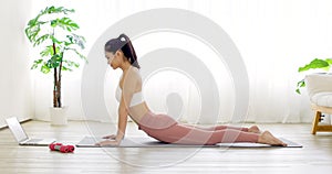 Young woman in  sportswear  doing sports training  on yoga mat at home