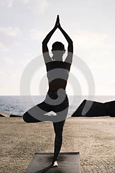 young woman in sportswear doing yoga position