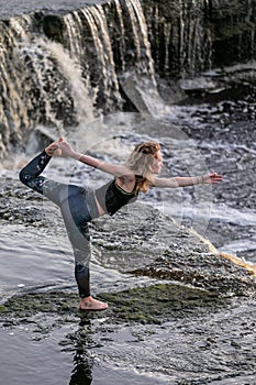 Young woman in sportswear practicing breathing yoga pranayama outdoors