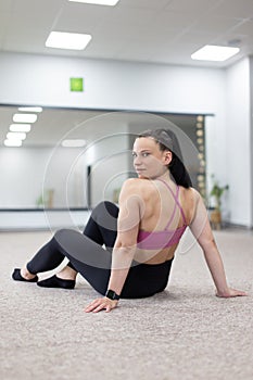 Young woman in sportswear resting and looking back vertical