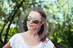 Young woman in sportswear standing outdoors in a park on sunny s