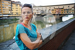 Young woman in sportswear is staying next to Ponte Vecchio