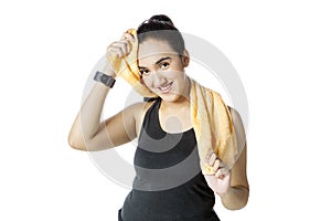 Young woman in sportswear wiping sweat in studio