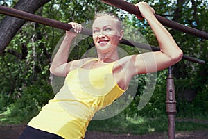 Young woman in sportswear working out outdoors in a park on sunny summer day.