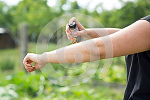 Young woman spraying mosquito, insect repellent in the forrest, insect protection, helathcare concept