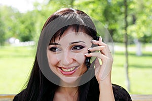 Young woman at spring park talking on the phone.