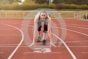 Young woman sprinter in the starter position