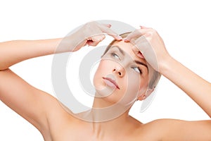 Young woman squeezing acne spots