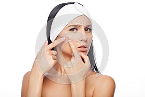 Young woman squeezing her pimple photo