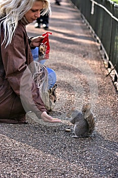 Young woman & squirrel, shearing snack.