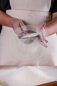 Young woman squirting a flour in an apron