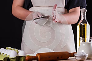 Young woman squirting a flour in an apron