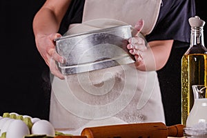 Young woman squirting a flour in an apron