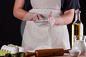 Young woman squirting a flour in an apron