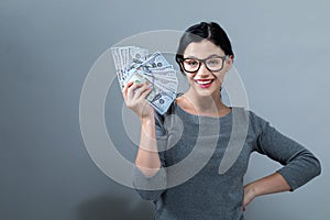 Young woman with a stack of cash USD