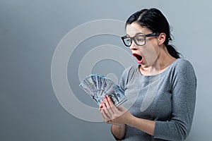 Young woman with a stack of cash USD