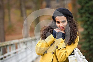 Young woman standing autumn park yellow coat