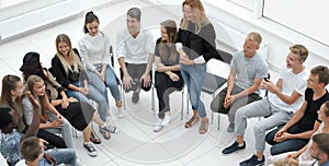 Young woman standing in a circle of business training participants