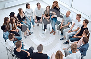 Young woman standing in a circle of business training participants