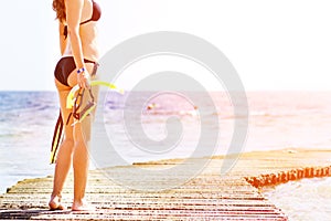 Young woman standing with equipment for snorkeling