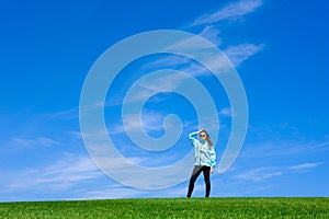 Young woman standing in field of green grass