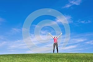 Young woman standing in field of green grass