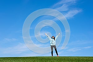 Young woman standing in field of green grass