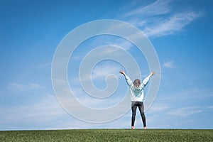 Young woman standing in field of green grass