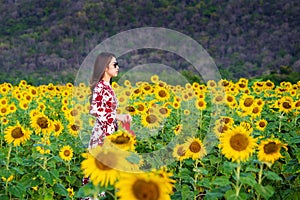 Young woman standing in a field of sunflowers