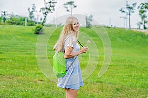 Young woman standing with folded inflatable sofa in the park. lamzac