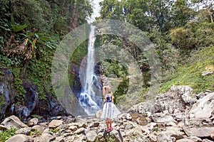 Young woman standing in front of Gitgit waterfall