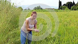 young woman standing in green wheat field