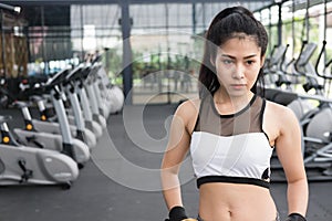 Young woman standing with hands on hip in fitness center. female