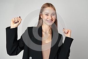 Young woman standing with her arms lifted high above her head expressing joy and triumph