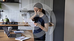 Woman reading letter with awful news feels frustrated photo