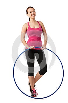 Young woman standing with hula hoop down