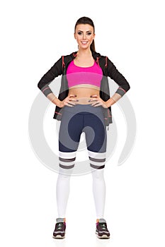 Young Woman Standing Legs Apart In Fitness Outfit. Front View.