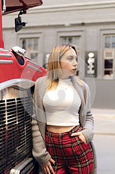 Young woman standing near London red bus