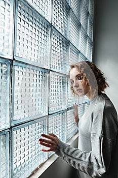 Young woman standing near window