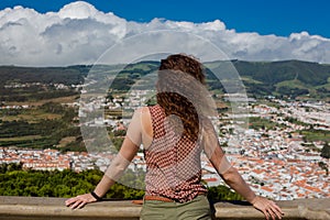 A young woman is standing in front of Angra do Heroismo, Terceira, Azores, Portugal. photo