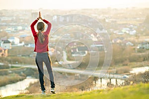 Young woman standing outdoors enjoying city view. Relaxing, freedom and wellness concept