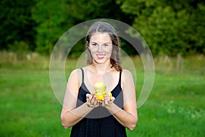 Young woman standing outdoors in nature and holding lemons