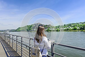 Young Woman Standing On Promenade By River In City During Summer