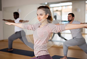 Young woman standing in Revolved High Lunge Pose during yoga class