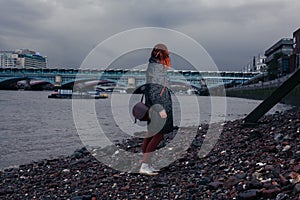 Young woman standing on river bank in city