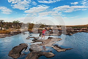 Young woman standing on the river between rocks